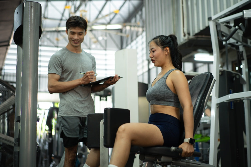 Frau macht Adduktoren Übungen im Fitnessstudio