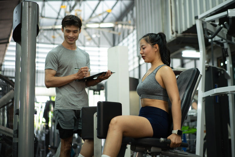 Frau macht Adduktoren Übungen im Fitnessstudio