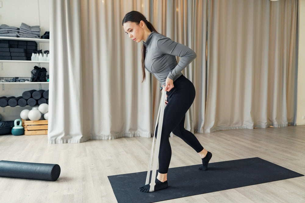 Frau trainiert mit Widerstandsbändern zu Hause