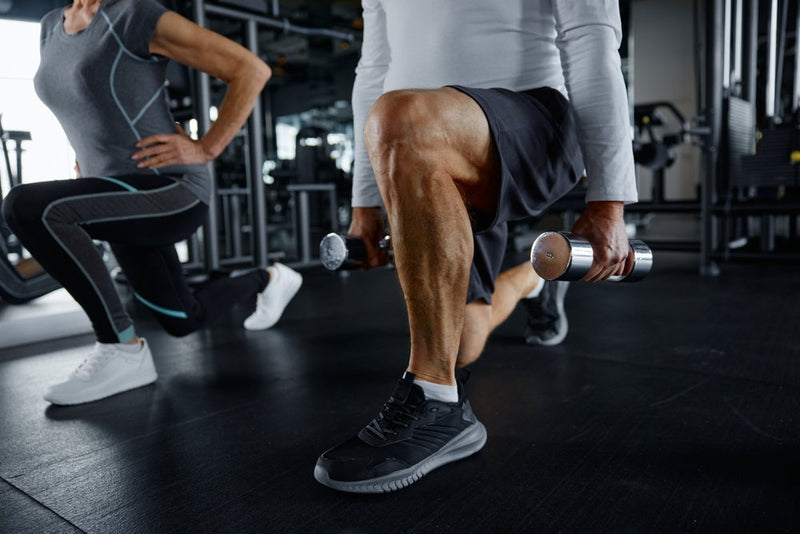 Mann trainiert Kniebeugen im Fitnessstudio