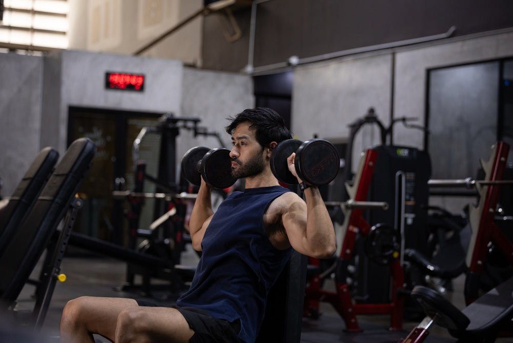 Mann macht Schulter Übungen im Fitnessstudio